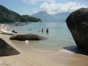 un grupo de personas en el agua en una playa en Pousada Alto de Junqueira en Mangaratiba