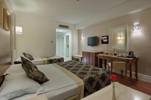 una habitación de hotel con una cama grande y una mesa en Alba Queen Hotel, en Side