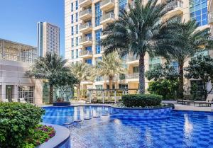 a swimming pool with palm trees and buildings at OYO 398 Home Standpoint Tower A , 1 BR in Dubai