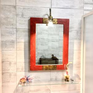 un espejo con un marco rojo en la pared en Flower Cozy room, en Venecia