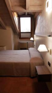 a bedroom with a large bed and a window at Hotel La Valle in Volta Mantovana