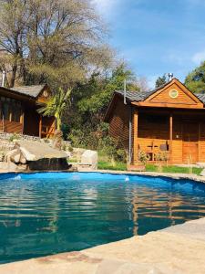 a house with a swimming pool in front of a house at Refugio del Maipo Lodge in San José de Maipo