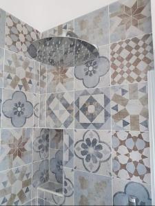 un baño con una pared de azulejos con flores. en Casa Vacanze Trinacria en Isola delle Femmine