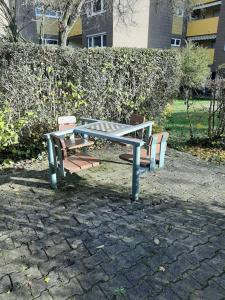 a picnic table and two benches sitting on a stone ground at Monteurswohnung Monteurunterkunft in Heilbronn