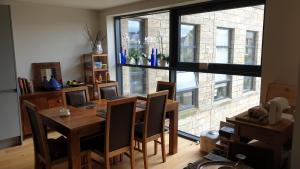 uma sala de jantar com uma mesa com cadeiras e uma grande janela em 1 double guest bedroom in my home North Leeds em Horsforth