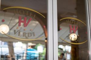 a window with the hirudu hotel signs on it at Hotel Verdi in Lido di Jesolo