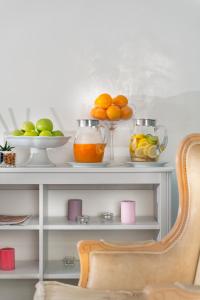 a shelf with bowls of oranges and other fruits on it at Hotel De Londres in Rimini