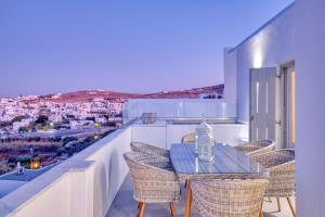 a table and chairs on a balcony with a view at White Cliff Naousa in Naousa