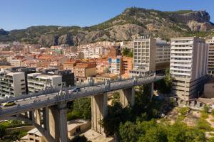 un tren cruzando un puente sobre una ciudad en Hotel Reconquista en Alcoy
