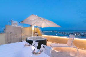 eine Terrasse mit einem Tisch, Stühlen und einem Sonnenschirm in der Unterkunft Locanda Alfieri in Termoli