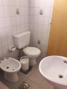 a white bathroom with a toilet and a sink at Amaneceres Las Grutas in Las Grutas +11 photos