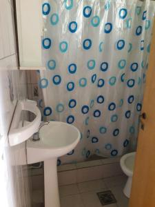 a bathroom with a sink and a shower curtain at Amaneceres Las Grutas in Las Grutas