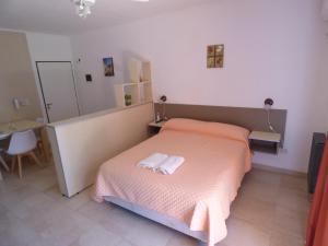 1 dormitorio con 1 cama con 2 toallas en Puerto Termas en Colón