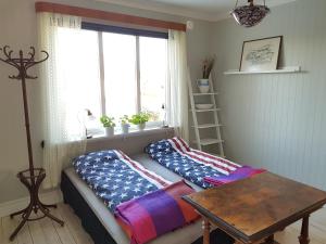 a room with two beds and a table and a window at Snickaren Vandrarhem i Grästorp - Egen Lägenhet - Own apartments in Grästorp