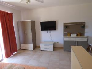 Una sala de estar con un televisor de pantalla plana en la pared. en Puerto Termas, en Colón