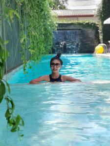 a woman is swimming in a swimming pool at Lemonade Phuket Hotel -SHA Plus in Chalong