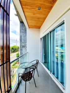 a balcony with a glass table and chairs on it at Lemonade Phuket Hotel -SHA Plus in Chalong