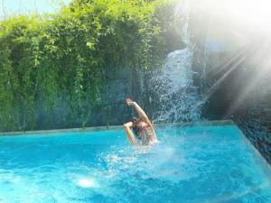 a person in a swimming pool in the water at Lemonade Phuket Hotel -SHA Plus in Chalong