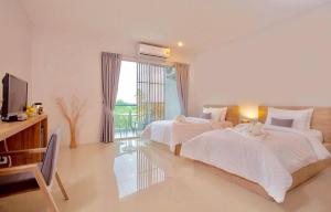 a bedroom with two beds and a television and a window at Lemonade Phuket Hotel -SHA Plus in Chalong