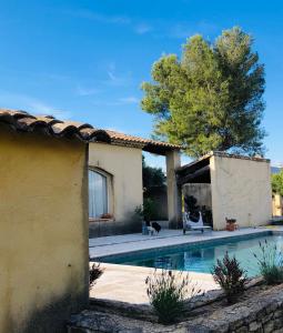 une maison avec une piscine dans une cour dans l'établissement Villa dans le LUBERON à 2 km de LOURMARIN, à Lauris