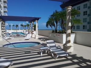 un patio con piscina y 2 sillas junto a un edificio en Chic and Modern, Brickell / Miami + FREE Parking, en Miami