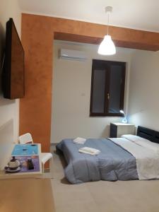 a bedroom with a bed and a tv and a table at F&L A TAORMINA in Taormina