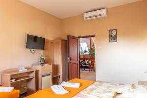 a hotel room with two beds and a television at Husz&aacute;r Panzi&oacute; &eacute;s &Eacute;tterem in S&aacute;rospatak