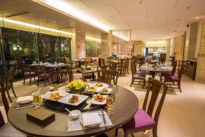 un ristorante con tavoli e sedie con cibo sopra di Dusit Princess Srinakarin Bangkok a Bangkok