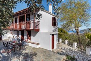 a house with a balcony and a table at Aletri Pool Cottage in Skopelos Town