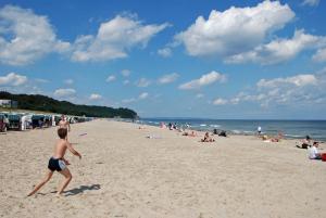 a young boy playing with a frisbee on the beach at Ferienhaus Augustin mit Reetdach u in Baabe