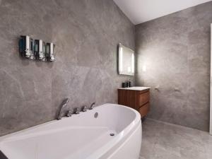 圣朱利安斯Duplex Maisonette with Heated P-Pool and Jacuzzi的带白色浴缸和水槽的浴室