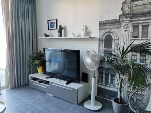 een woonkamer met een flatscreen-tv en een ventilator bij Duplex Maisonette with Heated P-Pool and Jacuzzi in St Julian's