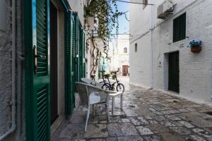 a bench in an alley with a bike on it at Alimarta in Monopoli
