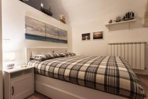 a bedroom with a bed with a plaid comforter at Alimarta in Monopoli
