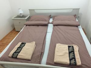 a double bed with two pillows on it in a bedroom at Apartman PEŠAČKA ZONA in Šabac