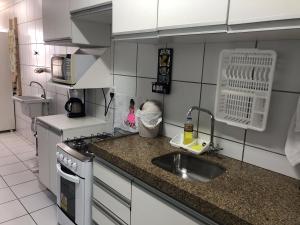 cocina pequeña con fregadero y fogones en Apt. para Família - Completo em Recife, Boa Viagem - 3 qts - p/ 6 pessoas - 300m da praia, en Recife
