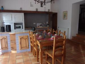 cocina con mesa de madera y sillas en una habitación en cheztitoine, en Pouzauges