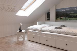 ein weißes Schlafzimmer mit einem Bett und einem Dachfenster in der Unterkunft Ferienwohnungen Bockstraße in Quedlinburg