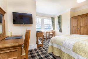 a hotel room with a bed and a flat screen tv at Crown Lodge in Harlech