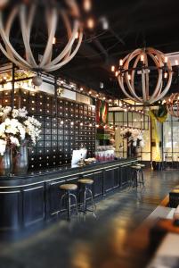 a restaurant with a bar with stools and flowers at M Boutique Hotel in Ipoh