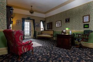 a living room with a red chair and a table at Crown Lodge in Harlech