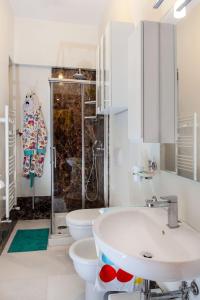 y baño con 2 aseos, lavamanos y ducha. en B&B Appia Felis en Roma