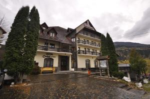 a large building with trees in front of it at Hotel Cerbul in Statjunea Borsa