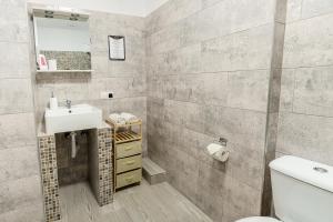 uma casa de banho com um lavatório e um WC em Select City Center Apartments em Brasov