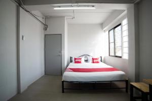 - une chambre avec un lit doté d'oreillers rouges dans l'établissement OYO 457 Panasan Villa, à Bangkok