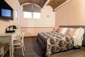Residenza Matilde في نابولي: غرفة نوم بسرير ومكتب وطاولة