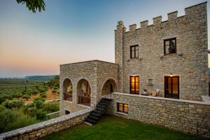 an exterior view of a stone building with a yard at Cassiopeia's Castle in Gythio