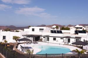 a swimming pool in front of a white house at Mana EcoRetreat in Las Breñas