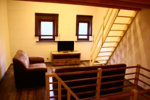 a living room with a couch and a tv and stairs at maison neuve en bois près de Pairy Daisa in Brugelette