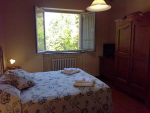 Un dormitorio con una cama y una ventana con toallas. en Badia il Vingone, en Città di Castello